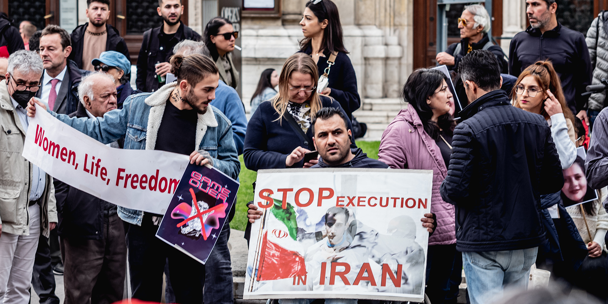 Protestierende halten Schilder hoch mit den Aufschriften 