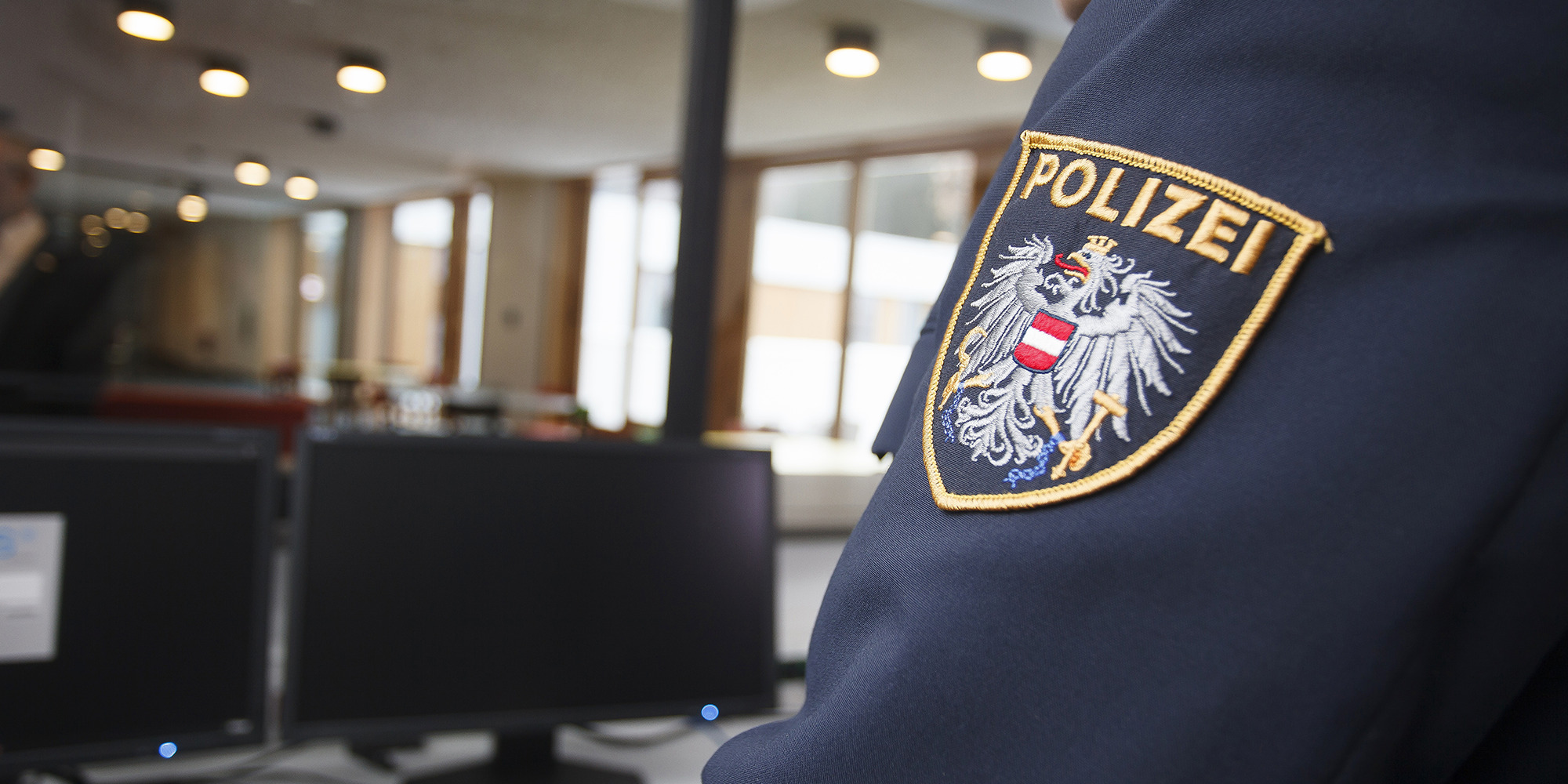 Ärmel einer Polizeijacke mit sichtbarem Abzeichen in einem Innenraum des Anhaltezentrums Vordernberg