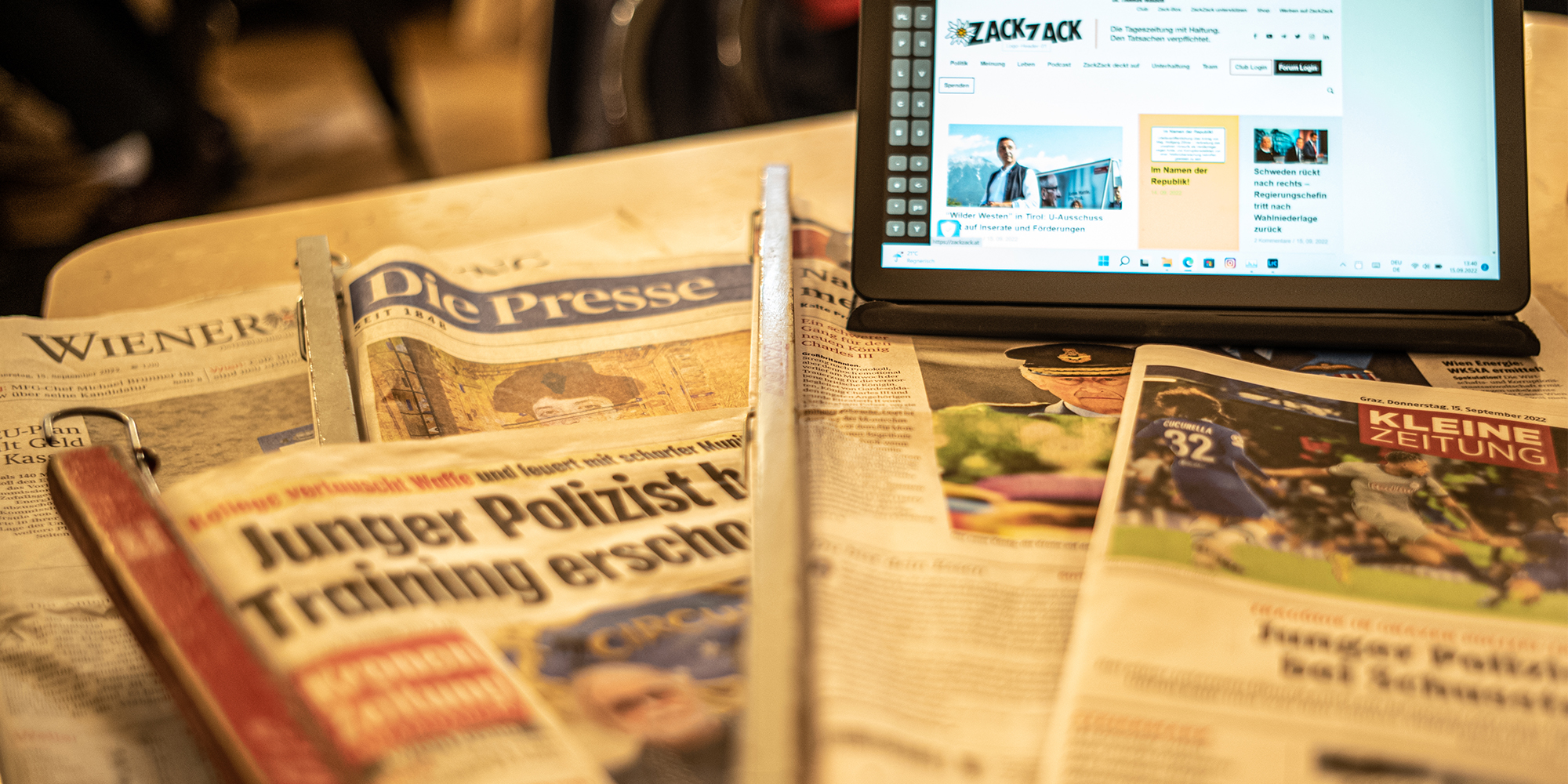 Tablet mit ZackZack-Website auf Zeitungen stehend