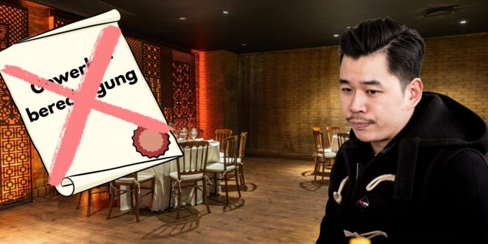Martin Ho ist vor einem Restaurant zu sehen. Links im Bildrand ist eine durchgestrichene Gewerbeberechtigung zu sehen.